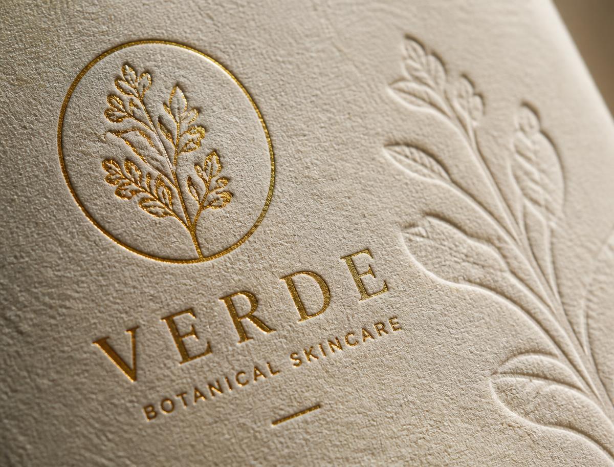 Macro detail of gold foil stamping and blind embossing on textured paper